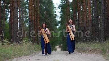 两个女<strong>竖琴</strong>手在森林里散步，在松树的背景下<strong>演奏竖琴</strong>。